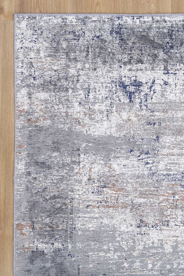 Blue and grey abstract rug with subtle distressed border. Eco-friendly and stain-resistant.