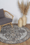 Alayah Ornamental Grey & Ash circle Rug on natural wooden floors with grey chair and rattan vases