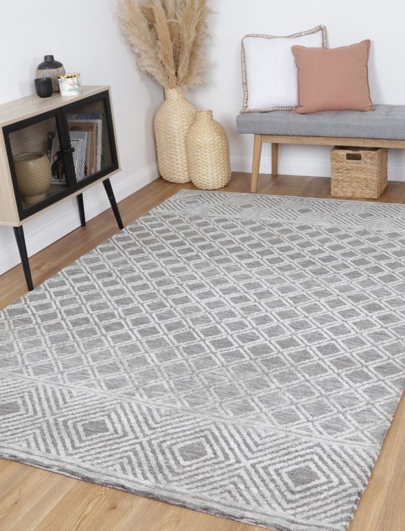 Alayah Diamond Trellis Silver Rug in sitting room with bench plants and wicker basket