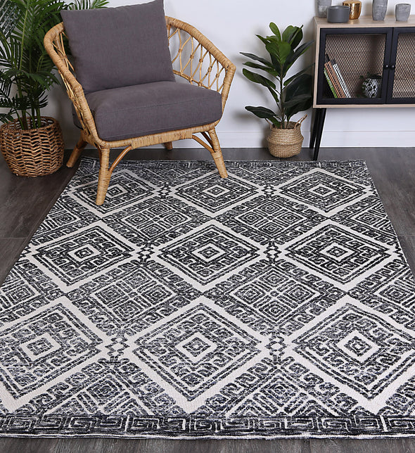 Alayah Diamond Grey Rug in living space with plants on grey floor boards