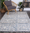 Alayah Tribal teal Rug on dark flooring with wicker backers and grey chair