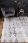 Almada indigo and ash Diamond Rug on timber flooring with grey arm chair with gold legs, black walls and a brass bowl