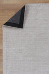 Allure Cotton Rayon Taupe Rug folded corner on wooden flooring